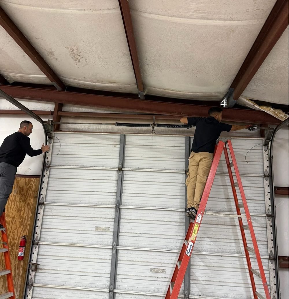 Fix N Leave technicians repairing a garage door